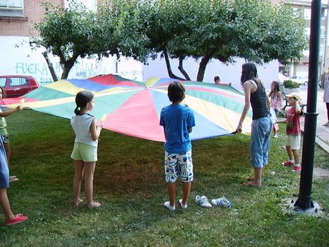 Juego del paracaídas en una fiesta infantil en el parque