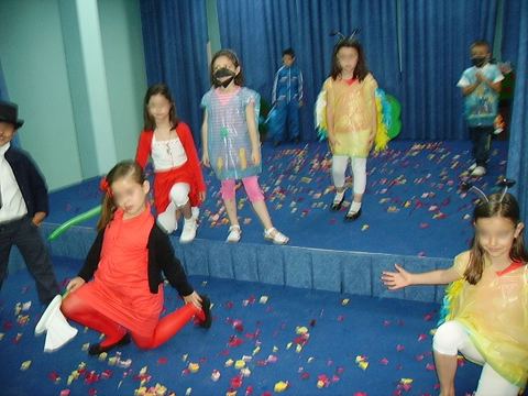 Escena de teatro infantil con niñas disfrazadas de pájaros