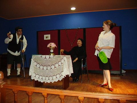 Escena teatral con varios personajes en el escenario
